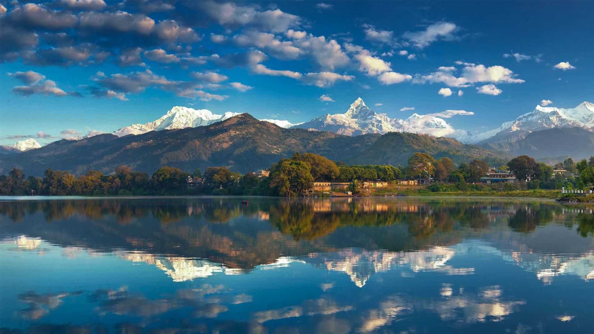Phewa lake with trees and mountains in the background- Annapurna Base Camp Trek - Phewa Lake is located in Kaski Pokhara. 